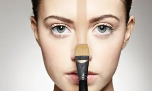 Un visage divisé par une bande de fond de teint trop foncé, appliqué avec un pinceau.