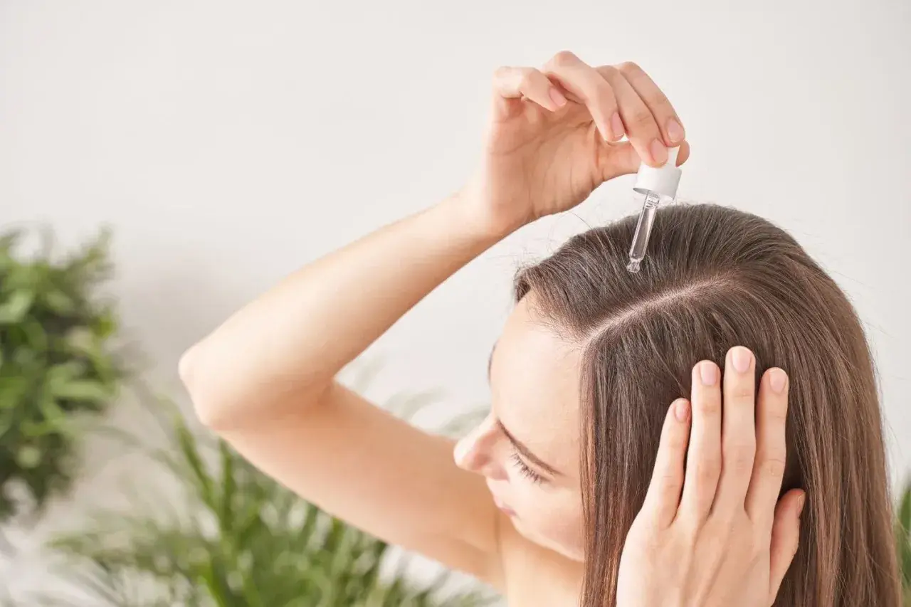 Application d'un sérum sur le cuir chevelu. Le résultat : des cheveux plus forts et brillants, un vrai "avant après" grâce à l'eau de rose.