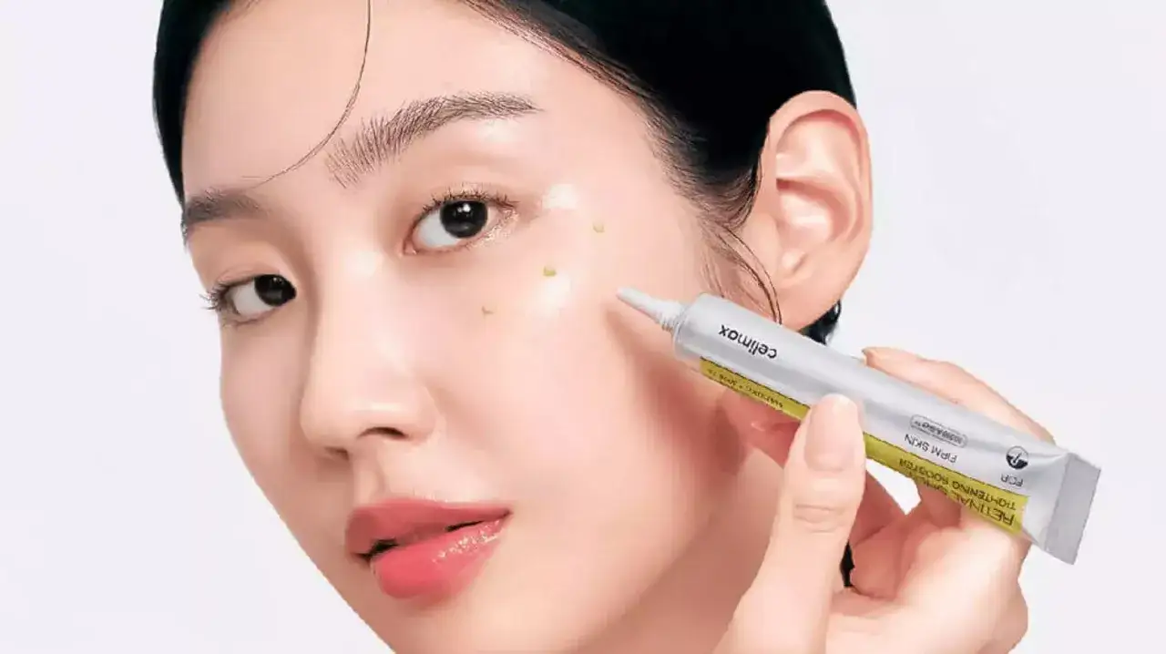Une femme applique un s&eacute;rum sur son visage. Le tube indique 