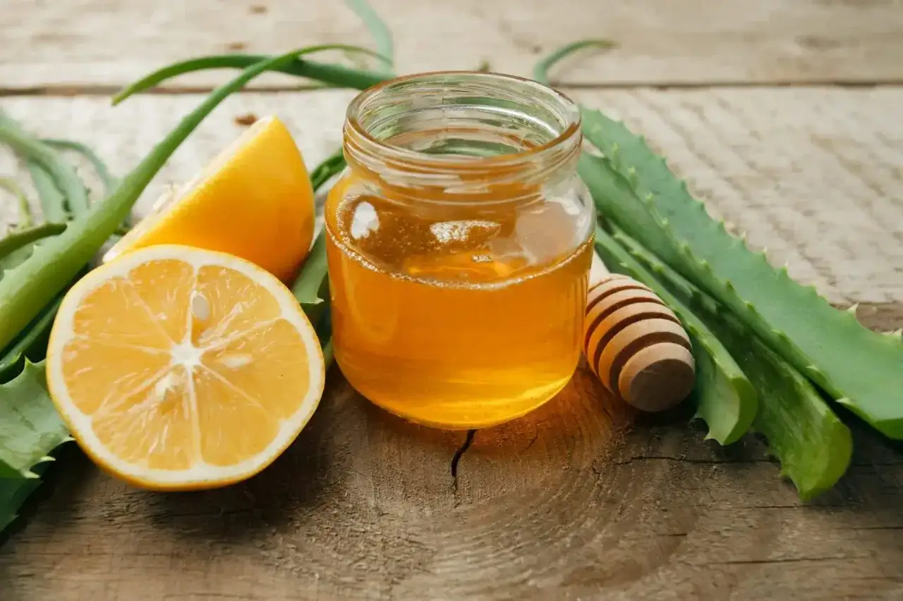 Un pot de miel dor&eacute;, des citrons frais et des feuilles d'aloe vera sur fond de bois. Un rem&egrave;de de grand-m&egrave;re contre les rides, naturel et efficace.